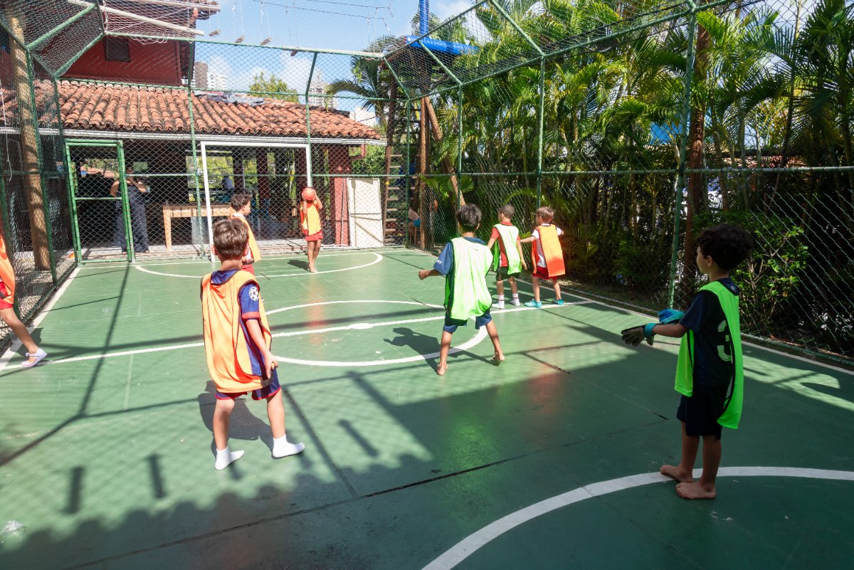 Crianças jogando futebol na quadra